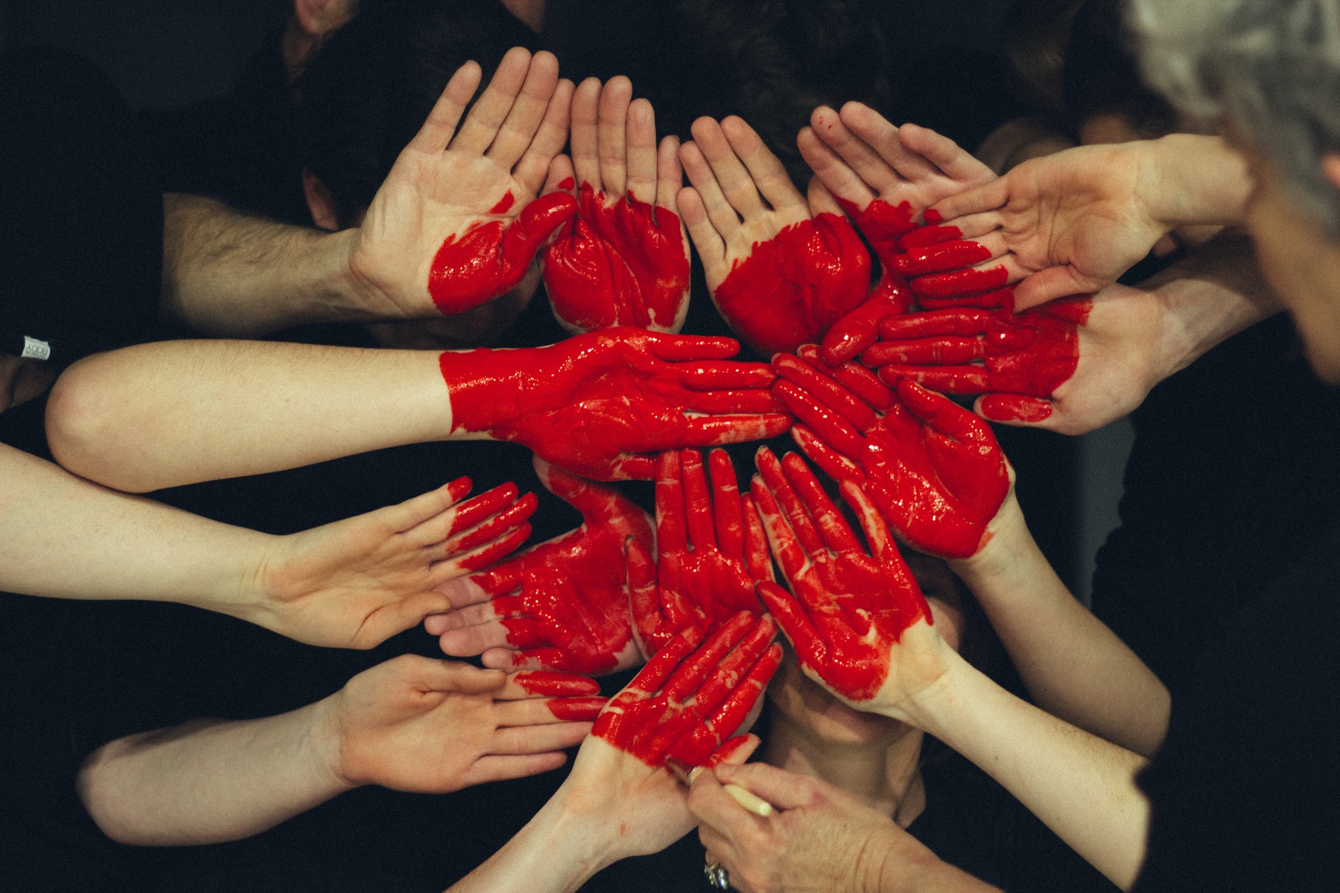 A bunch of painted hands together forming a red heart shape | Image credit: Tim Marshall via Unsplash.com