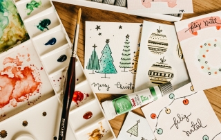handcrafted Christmas cards and art materials on a table | image source: pexels.com