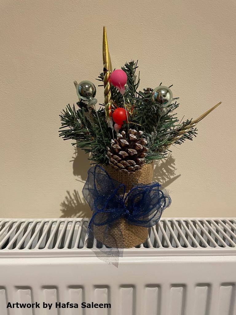 Photo of a festive plant arrangement. The text at the bottom-left reads 