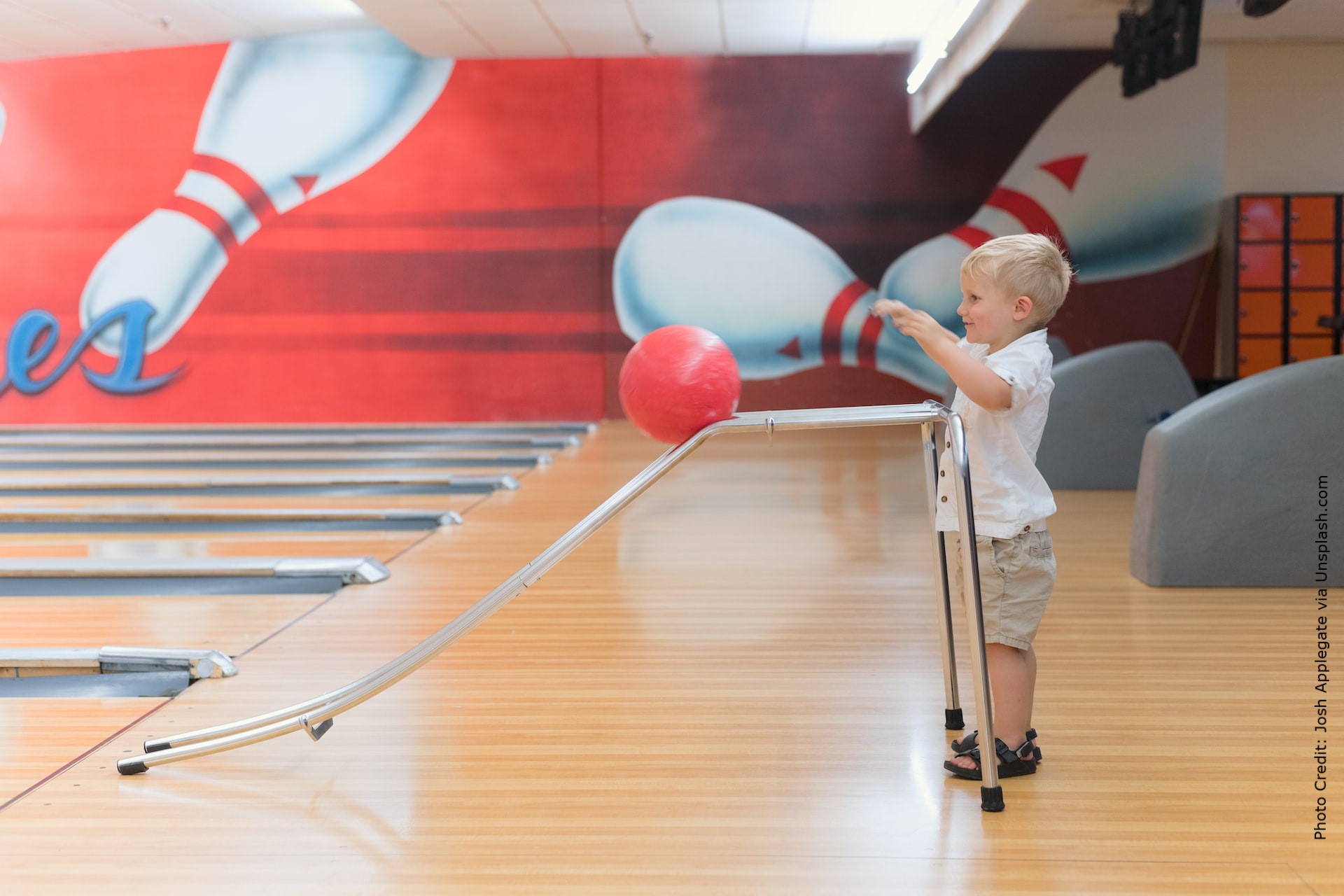 The image shows a young boy using a rack to bowl.