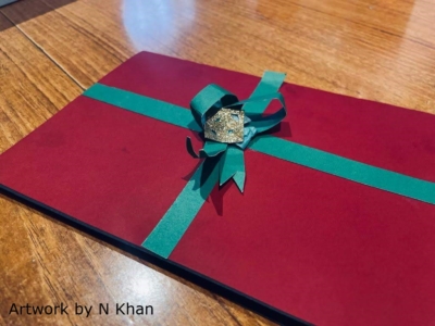 This shows the gift-looking cover of a pop-up card, in Christmassy colours green and red. The text at the bottom-left reads 