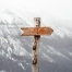 photo of a direction arrow on a pole, pointing right, with a white mountain in the background