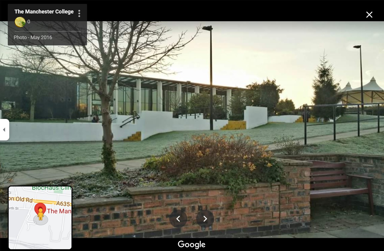 This screenshot of a photo at The Manchester College's Openshaw Campus shows the main building, the grassy lawn out front, and some gazebos to the side.