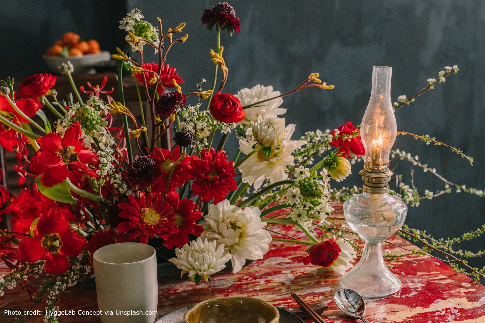 A lovely arrangement of red and white flowers set on a dining table