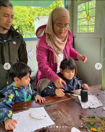 Photo shows a family of four doing crafts at a Manchester Bees Forest School session