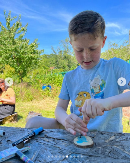 Photo shows a boy doing woodwork at a Manchester Bees Forest School session