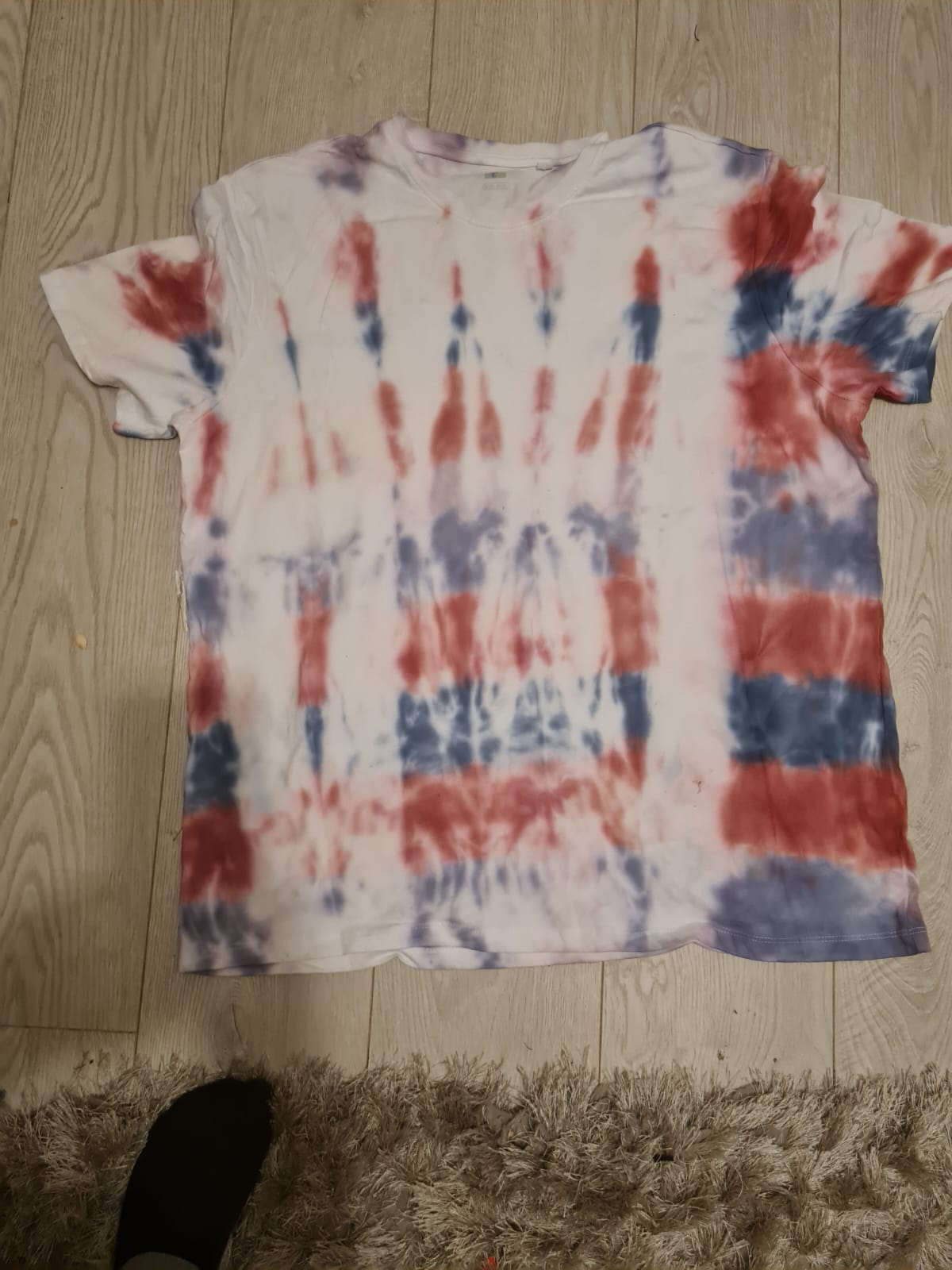 Photo shows a tie-dyed shirt with paints of red and blue