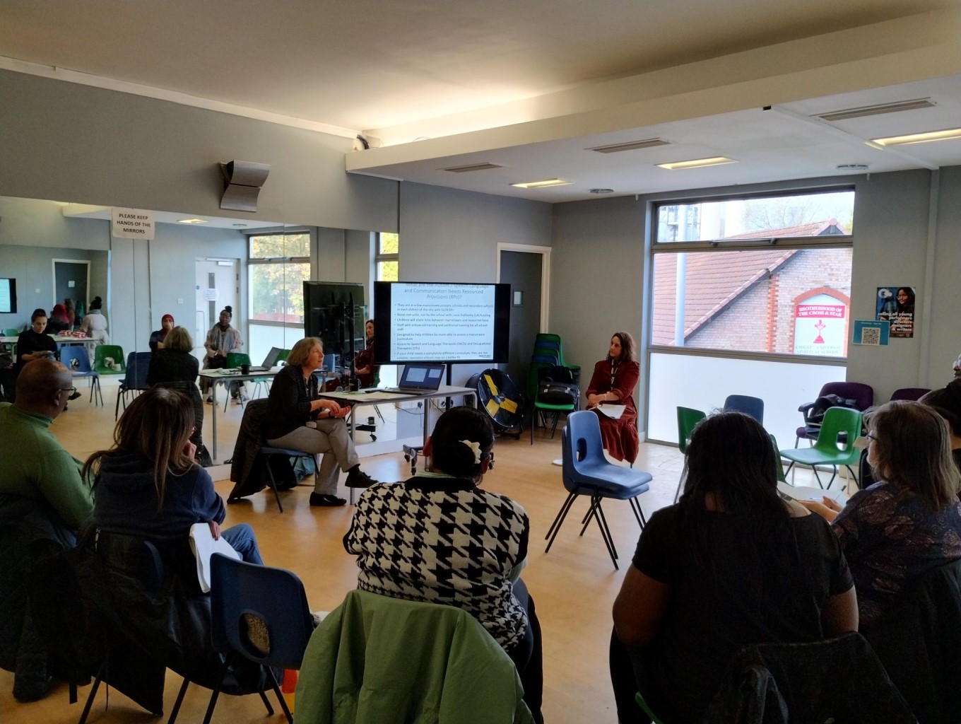 The image shows parents listening to educational psychologists at the "Exploring Types of Schools and Support for Children with SEND" workshop that was held in October 2023.